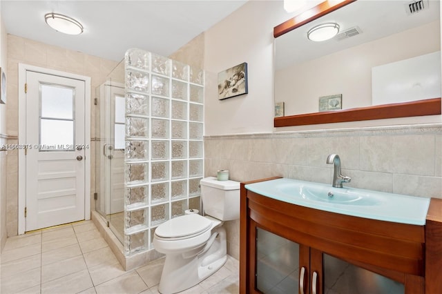 bathroom featuring tile walls, walk in shower, tile patterned floors, vanity, and toilet