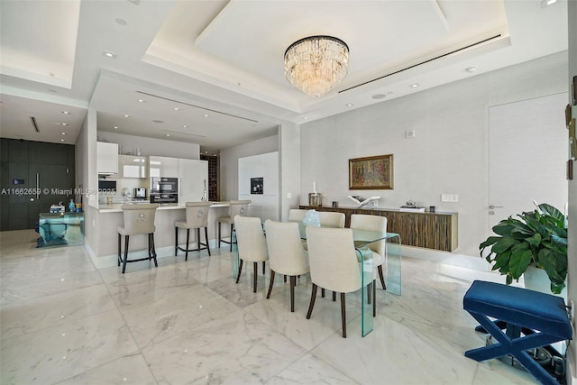 dining room with a raised ceiling and a notable chandelier