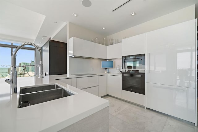 kitchen featuring white cabinetry, double oven, and sink