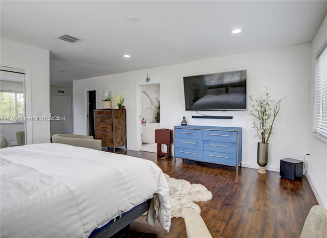 bedroom featuring connected bathroom and dark hardwood / wood-style floors