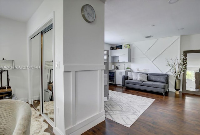 living room featuring beverage cooler and dark wood-type flooring