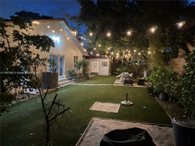 yard at twilight featuring a patio area and an outbuilding