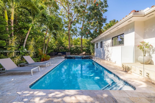 view of swimming pool featuring a patio area and an in ground hot tub