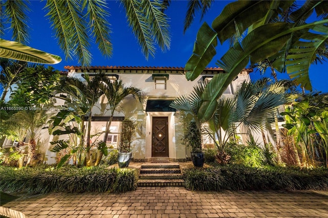 doorway to property featuring stucco siding