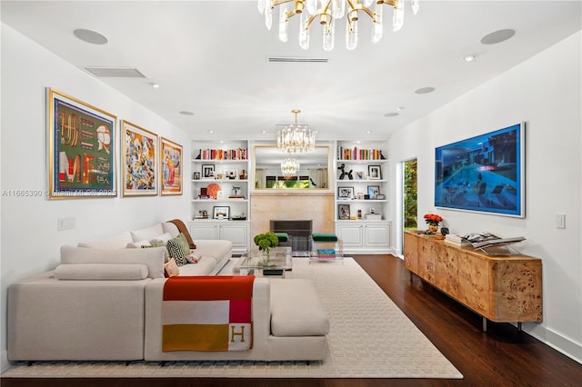 living area featuring a high end fireplace, visible vents, a chandelier, built in features, and dark wood-style flooring