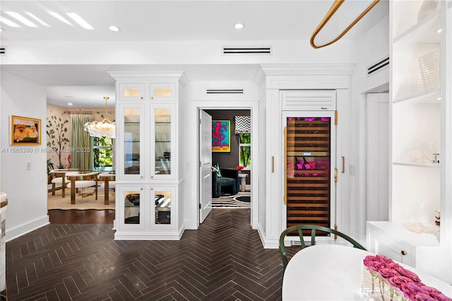 interior space featuring visible vents, baseboards, beverage cooler, recessed lighting, and an inviting chandelier