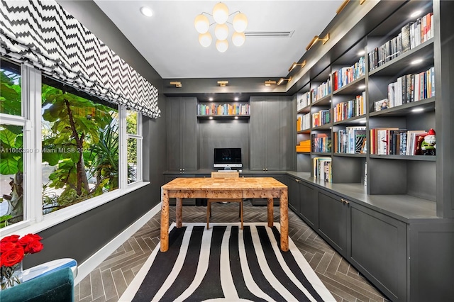 office area with an inviting chandelier and baseboards