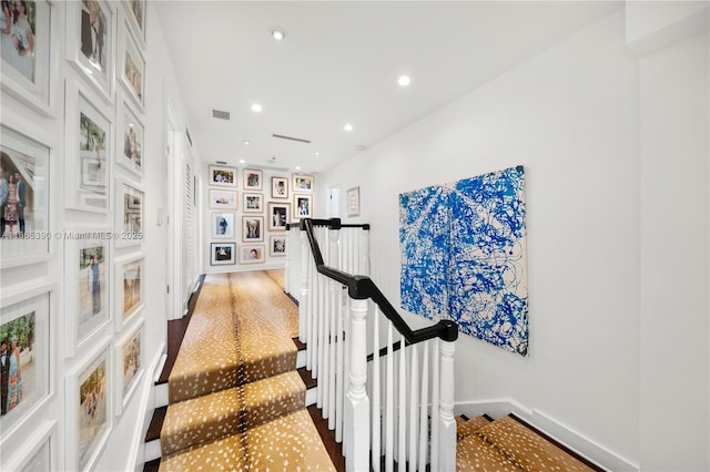 corridor with recessed lighting, an upstairs landing, visible vents, and baseboards