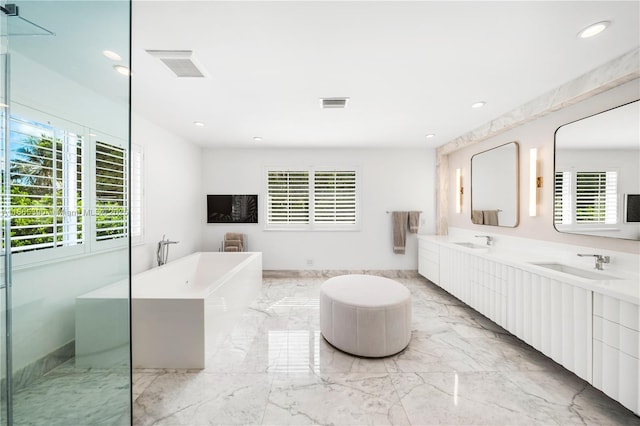 full bath with a freestanding tub, visible vents, marble finish floor, and a sink