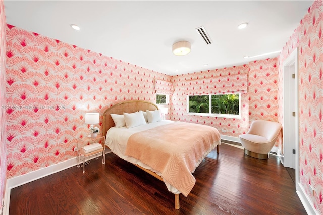 bedroom with wallpapered walls, baseboards, and wood finished floors