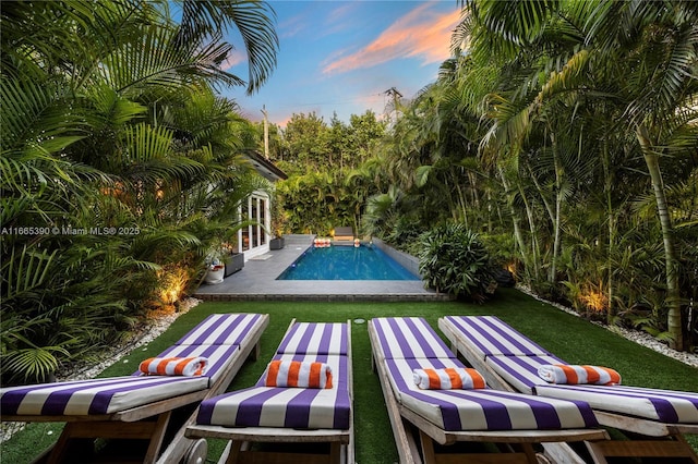 outdoor pool featuring a patio and a lawn