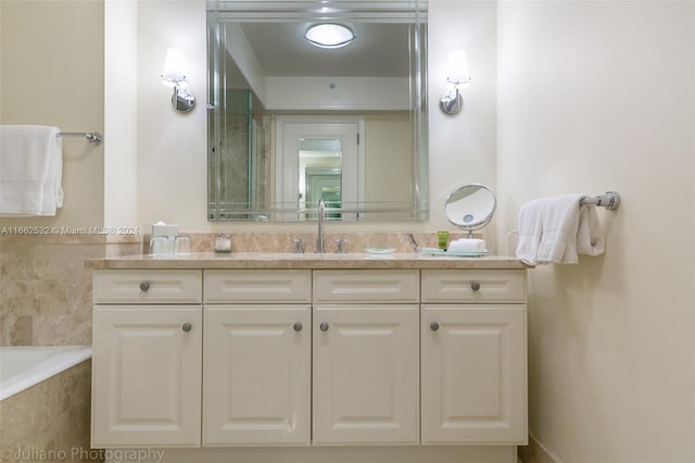 bathroom with a relaxing tiled tub and vanity