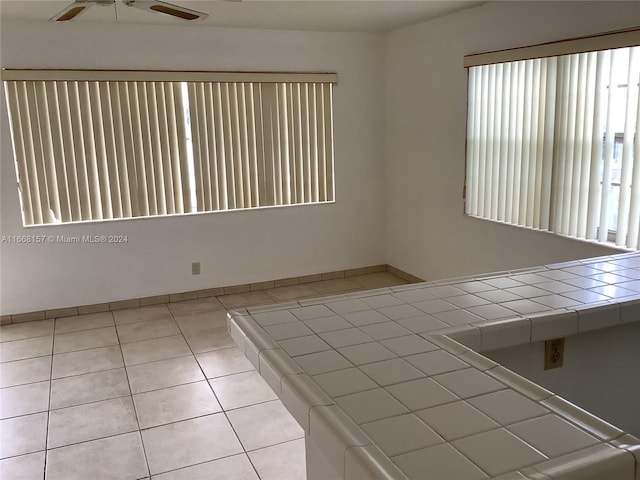 interior space with ceiling fan and light tile patterned floors