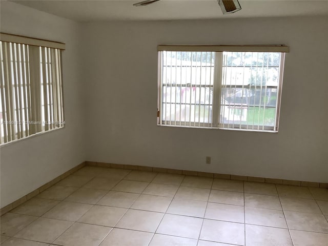 tiled spare room featuring ceiling fan