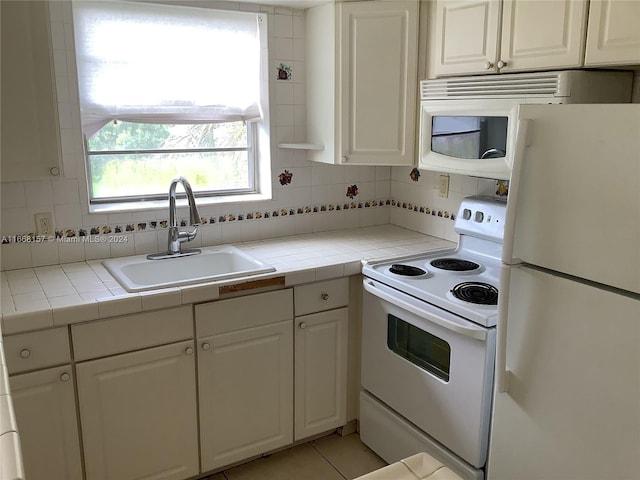 60 Windsor C Unit 60, West Palm Beach, FL 33417 - kitchen with white cabinets, tile countertops, a sink, white appliances, and decorative backsplash