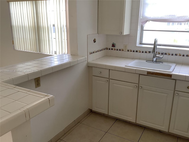 60 Windsor C Unit 60, West Palm Beach, FL 33417 - kitchen with tasteful backsplash, tile counters, a sink, light tile patterned flooring, and white cabinetry