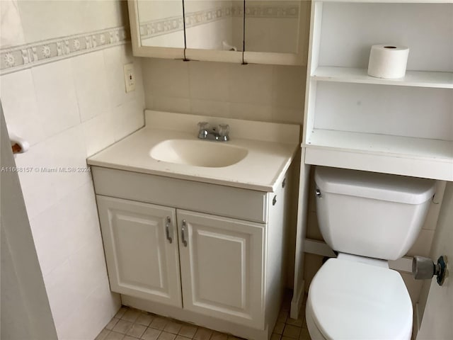 bathroom with vanity, tile walls, tile patterned flooring, and toilet