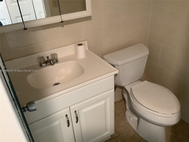 bathroom with tile walls, tile patterned floors, vanity, and toilet