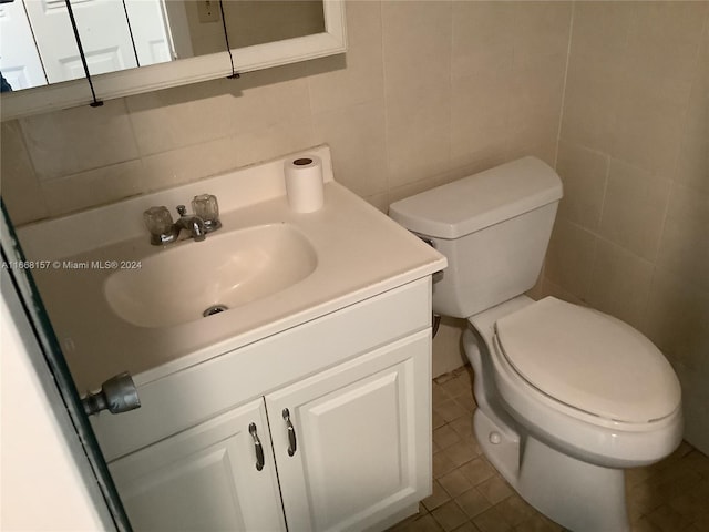 bathroom featuring vanity, tile walls, tile patterned flooring, and toilet