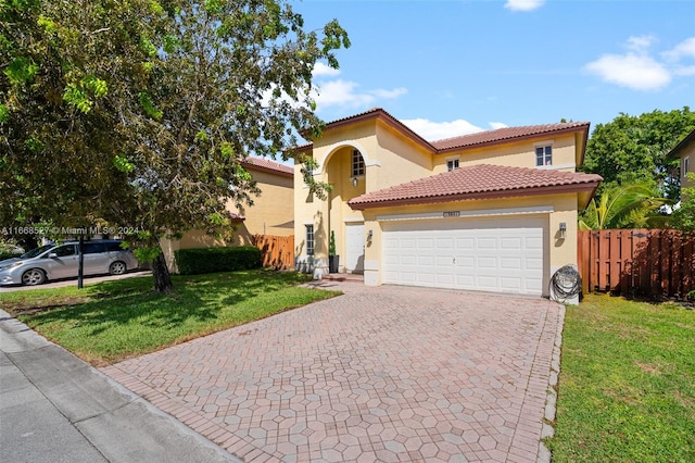 mediterranean / spanish-style house featuring a front lawn and a garage