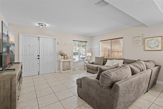 living room featuring light tile patterned flooring and a textured ceiling