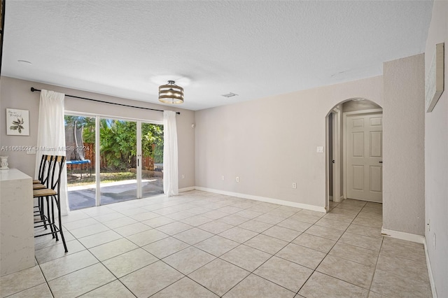 tiled spare room with a textured ceiling