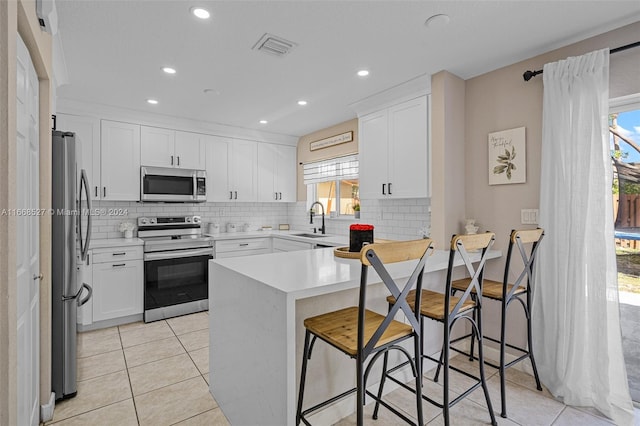 kitchen with kitchen peninsula, sink, stainless steel appliances, and a wealth of natural light