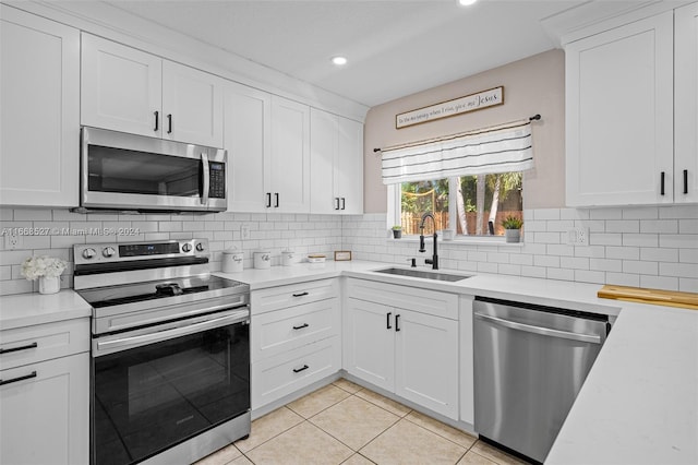 kitchen featuring backsplash, stainless steel appliances, white cabinets, and sink