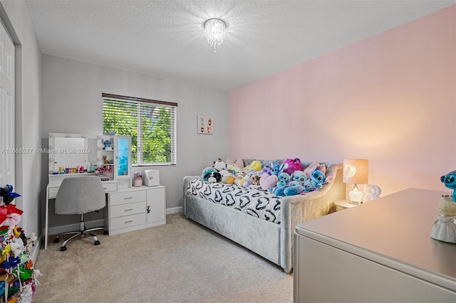 bedroom with a textured ceiling and light colored carpet