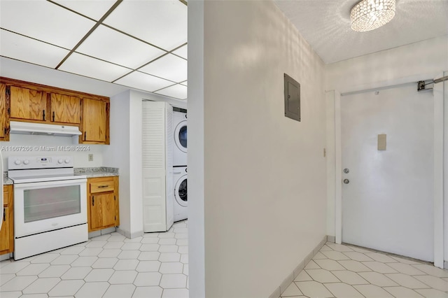 kitchen with stacked washer / dryer, electric panel, a chandelier, and white electric range