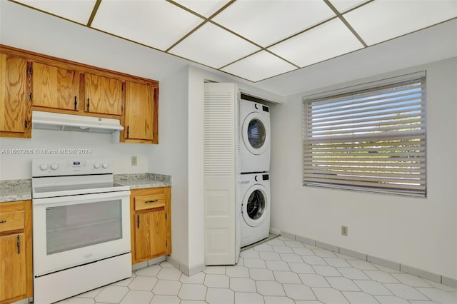 kitchen with stacked washer / drying machine and white electric stove