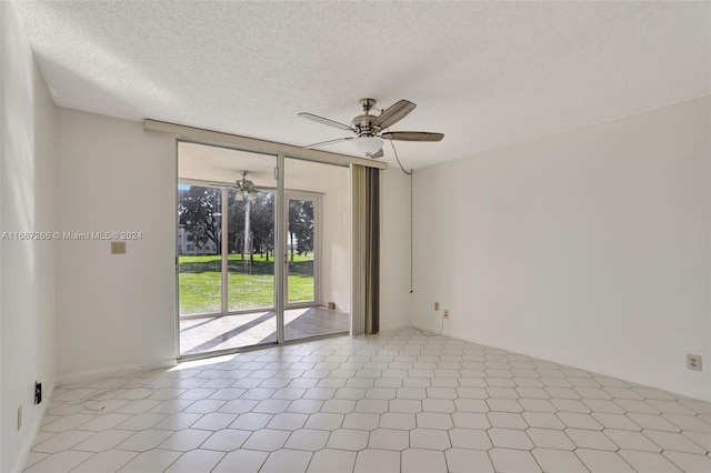 spare room featuring light tile patterned floors and a textured ceiling