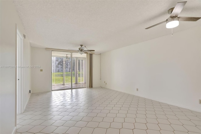 empty room with ceiling fan and a textured ceiling