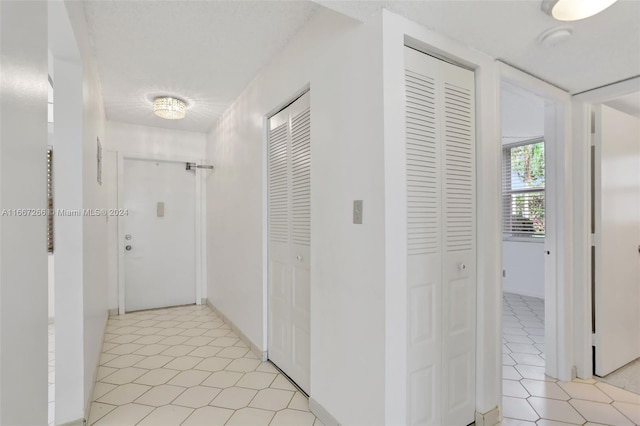 hall with light tile patterned floors