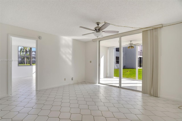 tiled empty room with ceiling fan and a textured ceiling