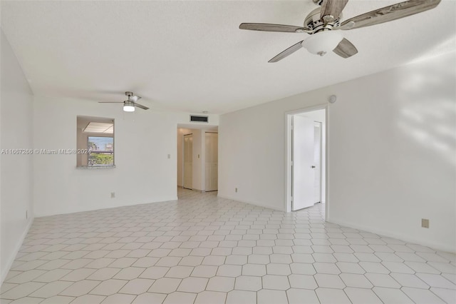 tiled spare room with ceiling fan