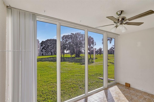 unfurnished sunroom with ceiling fan and a healthy amount of sunlight