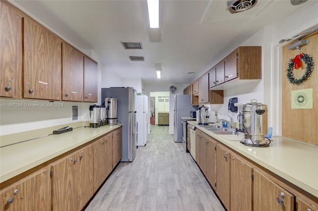 kitchen with stainless steel fridge, light hardwood / wood-style floors, and sink