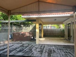 exterior space featuring a gazebo, a hot tub, and a wooden deck