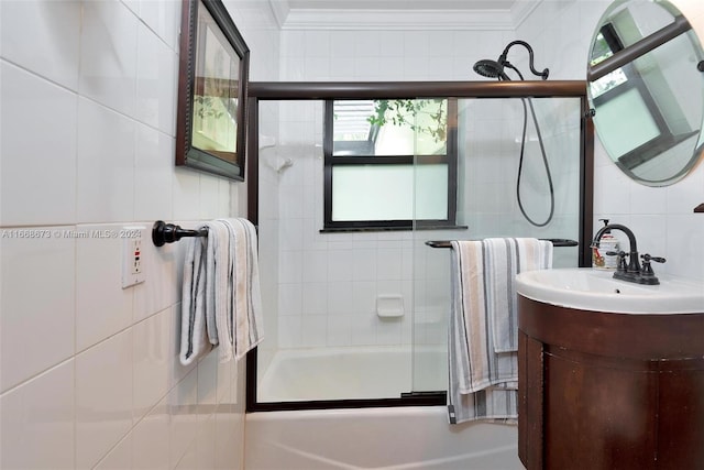 bathroom featuring enclosed tub / shower combo, crown molding, vanity, and tile walls