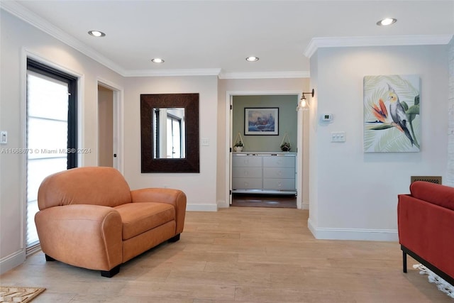 sitting room with crown molding and light hardwood / wood-style floors