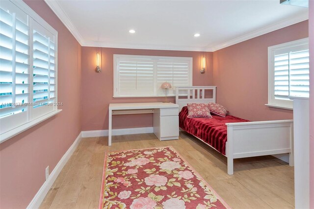 bedroom featuring crown molding and light hardwood / wood-style flooring