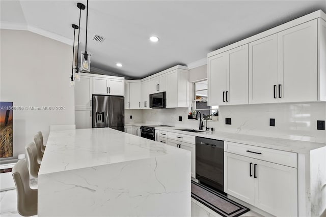 kitchen with black appliances, decorative light fixtures, light stone counters, and sink