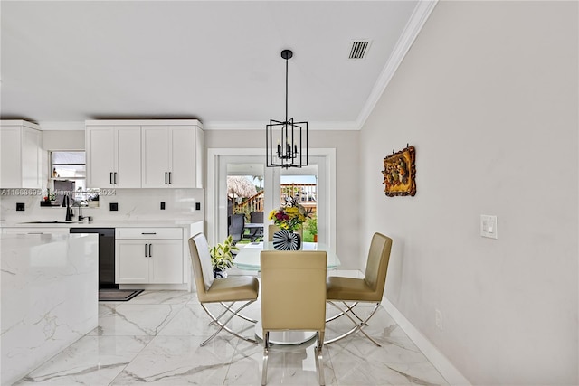 dining space featuring a notable chandelier, crown molding, and sink