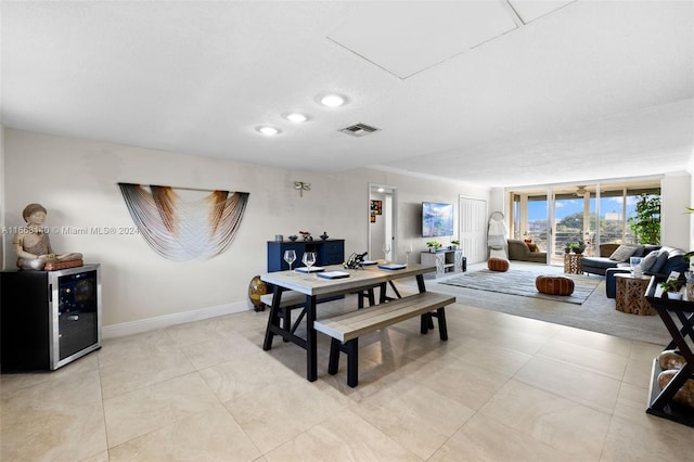 tiled dining space featuring a textured ceiling and beverage cooler