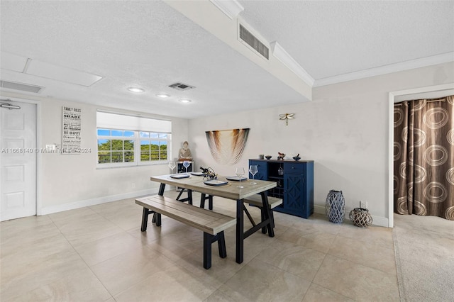 tiled dining area with a textured ceiling and crown molding