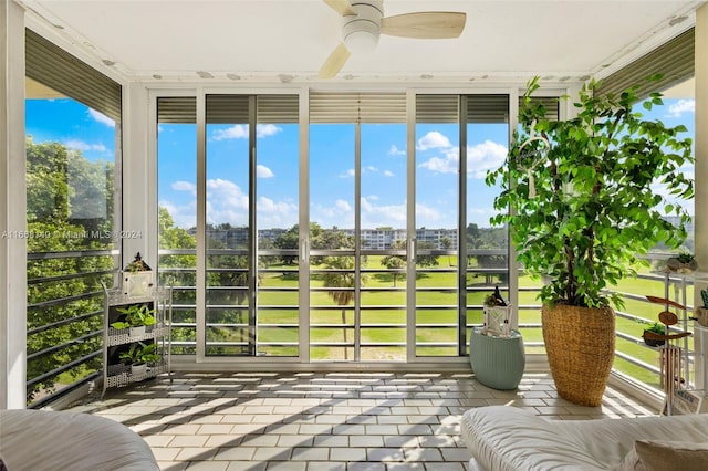 unfurnished sunroom featuring ceiling fan and plenty of natural light