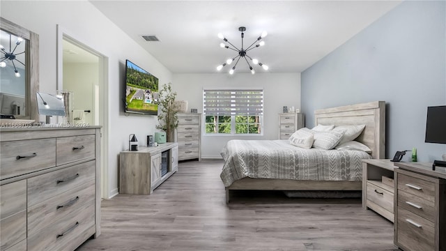 bedroom with hardwood / wood-style flooring and a chandelier