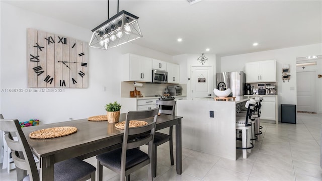 dining space featuring an inviting chandelier and light tile patterned flooring