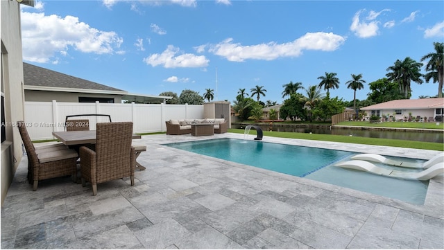 view of pool with pool water feature, a water view, and a patio area